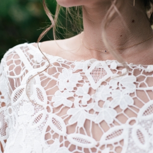 Детайл от булчинска рокля с дантела – сватбена фотография отблизо