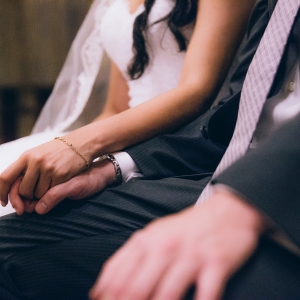 Младоженци държат ръцете си – романтичен момент от сватбена фотосесия