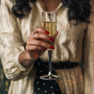 Жена държи чаша шампанско – елегантно събитие и парти атмосфера